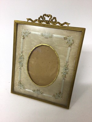 Lot 142 - Good quality Edwardian gilt metal photograph frame with ribbon cresting and embroidered silk floral border to mount and easel back 23.9 x 18cm