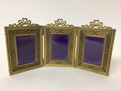 Lot 144 - Good quality Edwardian gilt metal folding triptych photograph frame with triple ribbon crestings and classical motive decoration and silk lined backing. Opening to 32.5 x 16.2