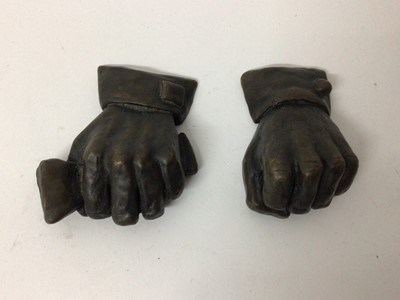 Lot 152 - Stephen Lansley, two bronze studies of human fists, one holding a newspaper, both signed with initials 7.5 cm approx.