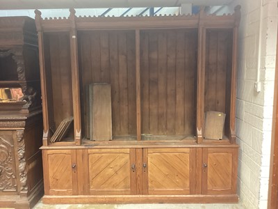 Lot 1221 - Victorian Gothic taste pitch pine bookcase, with open upper section and cupboards below