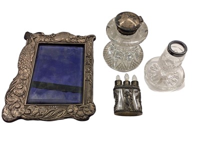 Lot 1034 - Art Nouveau silver photograph frame with peacock design, silver topped glass inkwell, silver collared glass match holder/striker, and a trio of silver mounted miniature glass scent bottles