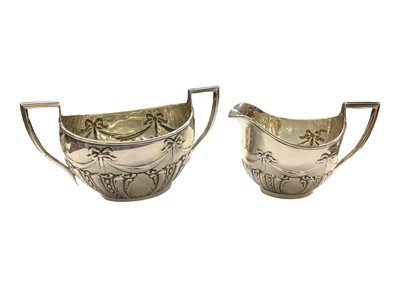 Lot 1041 - Silver sugar bowl and cream jug, both with embossed bow and ribbon swag decoration (Birmingham 1909)