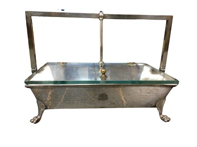 Lot 160 - An unusual silver plated box, the glass top opening with a cantilever mechanism, on four paw feet, the front with engraved coat of arms, possibly used in government offices, 30.5cm wide