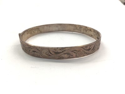 Lot 1058 - 1970s silver bangle with engraved foliate scroll decoration to one side and large hallmarks to the other (Birmingham 1977), 18cm inner diamater