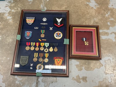 Lot 552 - Two glazed frames containing various American military medals, badges and insignia.