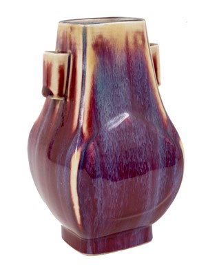 Lot 1 - A Chinese sang-de-boeuf vase, of Hu form with arrow handles, with a streaked red and purple glaze, 19th/20th century, 21.5cm high