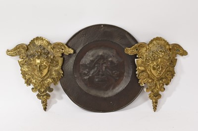 Lot 838 - Pair of large 19th century ormolu furniture mounts, in the form of angel masks, 20cm high, together with a Newlyn type copper dish, and a framed 18th century textile fragment