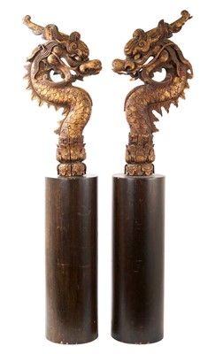 Lot 886 - Pair of Oriental carved wood dragon heads raised on plinths