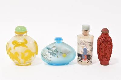 Lot 883 - Peking style overlay glass snuff bottle, 8cm high, together with two inside painted snuffs and a cinnabar lacquer snuff bottle. (4)