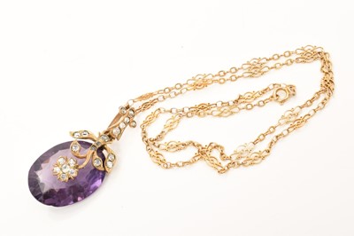 Lot 602 - Oval mixed cut purple stone in a floral paste set gilt metal pendant mount on a fancy link yellow metal chain