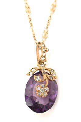 Lot 602 - Oval mixed cut purple stone in a floral paste set gilt metal pendant mount on a fancy link yellow metal chain