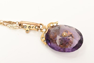 Lot 602 - Oval mixed cut purple stone in a floral paste set gilt metal pendant mount on a fancy link yellow metal chain