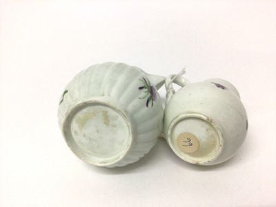 Lot 64 - Two 18th century Worcester sparrow beak cream jugs, one with a fluted body, both polychrome decorated with floral sprays, 8.75cm and 10.5cm high