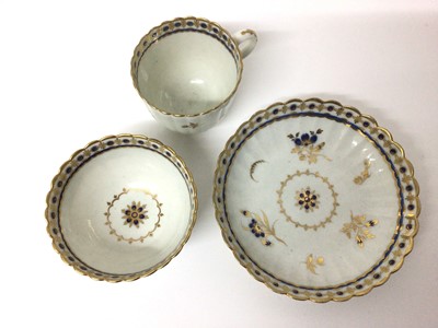 Lot 66 - Caughley trio, circa 1790, of fluted form, decorated in underglaze blue and gilt with floral sprays, 'S' marks, the saucer 13.5cm diameter