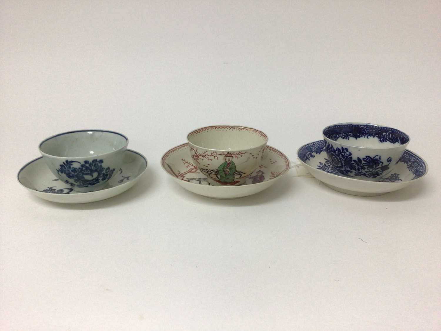 Lot 67 - Three 18th century Liverpool tea bowls and saucers, including one decorated in polychrome enamels with Chinese figures, one with fruit and another with flowers