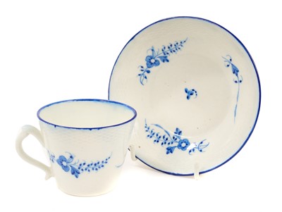 Lot 69 - Caughley coffee cup and saucer, circa 1785, painted in blue with the Chantilly Sprigs pattern, with basket weave moulded borders, line-painted rims, the saucer 12.5cm diameter