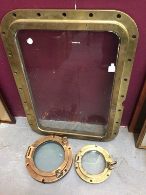 Lot 318 - Two brass ship's port holes and a brass framed glass ship's window panel (3)