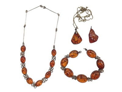 Lot 1054 - Silver mounted amber necklace and bracelet, together with two amber pendants