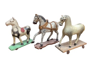 Lot 1577 - Three 19th century child's carved horses on wheeled bases