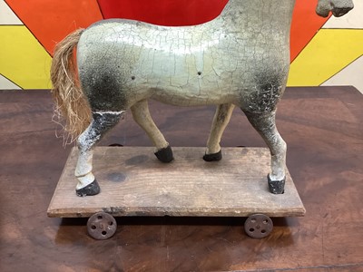 Lot 1577 - Three 19th century child's carved horses on wheeled bases