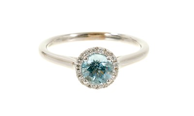 Lot 628 - Aquamarine and diamond cluster ring with a round mixed cut aquamarine surrounded by a border of brilliant cut diamonds in 18ct white gold setting