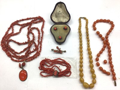 Lot 1061 - Antique long coral necklace with a carnelian oval pendant, coral bracelet, set of three coral studs in fitted case, coral bar brooch and two amber-type bead necklaces