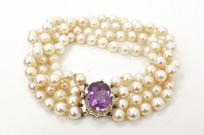 Lot 528 - Cultured pearl four strand bracelet with an amethyst and diamond set oval clasp