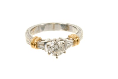 Lot 611 - Diamond single stone ring with a brilliant cut diamond estimated to weigh approximately 0.60cts flanked by tapered baguette cut diamonds to the shoulders in 18ct white and yellow gold setting with...