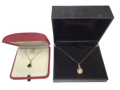 Lot 217 - Sapphire and marquise cut diamond pendant in gold mount on chain and a cultured pearl and diamond pendant in gold mount on chain (2)