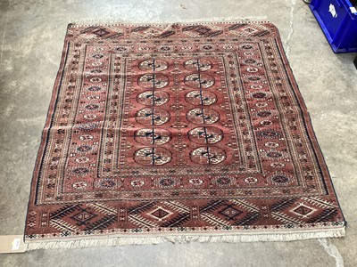 Lot 1378 - Eastern rug with geometric decoration on red ground, 115cm x 116cm