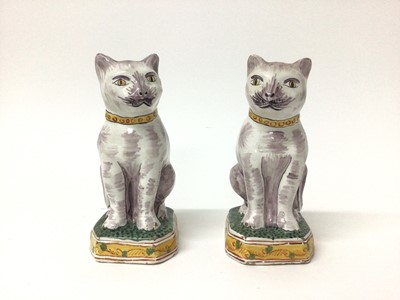 Lot 80 - Pair of Dutch delftware cats, 19th/20th century, modelled seated on octagonal bases, polychrome painted, with 'AK' marks to bases, 17.5cm high