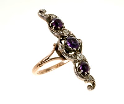 Lot 453 - Edwardian amethyst and diamond ring with a finger-line scrolling openwork foliage with amethysts and diamonds in silver setting on gold shank