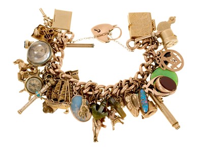 Lot 481 - Antique gold charm bracelet with a collection of antique and vintage gold and gilt metal charms to include a WWI 'Fumsup' lucky charm.