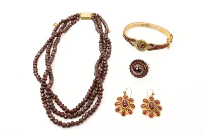 Lot 494 - Group of antique garnet jewellery to include a 19th century Bohemian garnet hinged bangle, similar cluster ring, a pair of earrings and a garnet faceted bead three strand necklace (4)