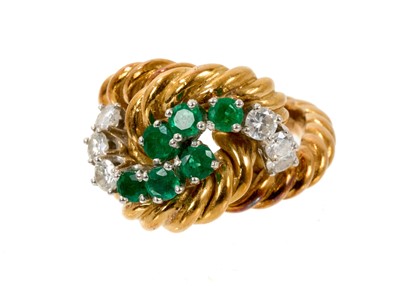 Lot 567 - Emerald and diamond cocktail ring with round mixed cut emeralds and brilliant cut diamonds in knotted design on 18ct gold rope twist shank, ring size L.