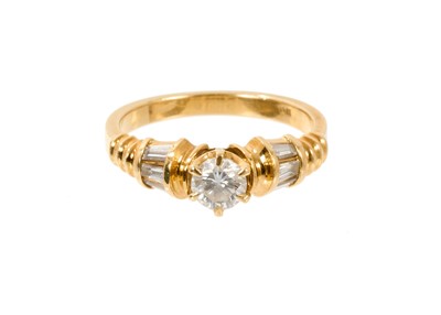 Lot 571 - Diamond single stone ring with a round brilliant cut diamond estimated to weigh approximately 0.40cts in claw setting flanked by tapered baguette cut diamonds to the shoulders on 18ct gold shank, e...