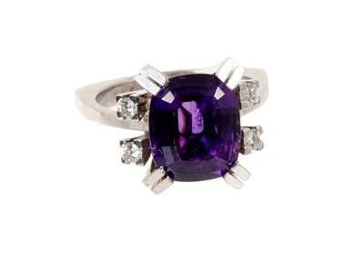 Lot 576 - 1970s amethyst and diamond ring with a cushion cut amethyst with exaggerated double claws flanked by brilliant cut diamonds to the shoulders on 18ct white gold shank, ring size O.