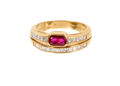 Lot 581 - Ruby and diamond two-row ring, the two diamond bands set with a step cut ruby and square step cut diamonds, in 18ct gold channel setting, ring size M½.