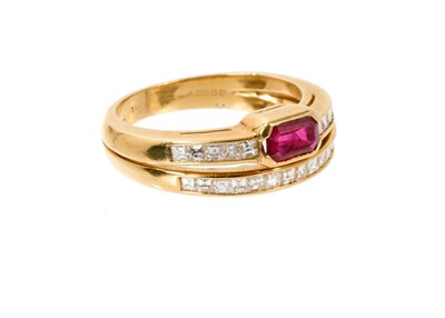 Lot 581 - Ruby and diamond two-row ring, the two diamond bands set with a step cut ruby and square step cut diamonds, in 18ct gold channel setting, ring size M½.