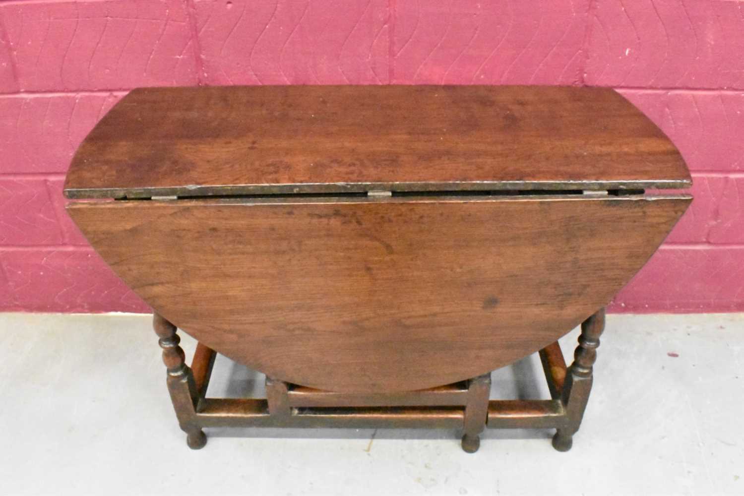 Lot 1389 - Late 17th century joined oak drop leaf dining table, with elliptical hinged top on turned and block understructure, 115 x 147cm extended