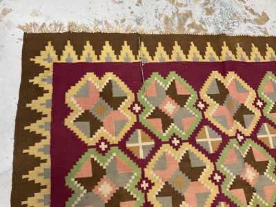 Lot 1424 - Large Kelim rug, with repeat cruciform motif on puce ground, signed, 310 x 197cm