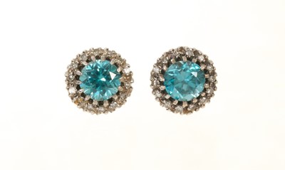 Lot 679 - Pair of blue zircon and diamond cluster earrings with a round mixed cut blue zircon surrounded by a border of single cut diamonds in white gold setting, 10mm.