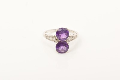 Lot 677 - Amethyst and diamond ring with two round mixed cut amethysts flanked by diamond set shoulders on18ct white gold shank, ring size O.