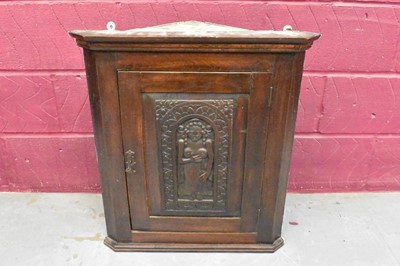 Lot 1416 - 18th century oak hanging corner cupboard, utilising an earlier oak fertility carving