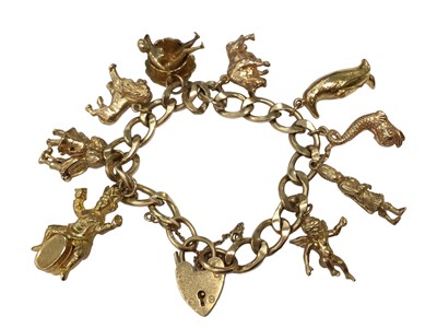 Lot 118 - 9ct gold gold curb link charm bracelet with nine gold novelty charms