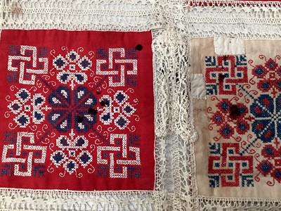Lot 2069 - A selection of vintage textiles including an East European patchwork cover with geometric cross stitch panels connected with bobbin lace, small velvet patchwork panel, Iranian printed cotton cover...
