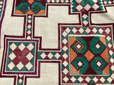 Lot 2069 - A selection of vintage textiles including an East European patchwork cover with geometric cross stitch panels connected with bobbin lace, small velvet patchwork panel, Iranian printed cotton cover...