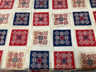 Lot 2069 - A selection of vintage textiles including an East European patchwork cover with geometric cross stitch panels connected with bobbin lace, small velvet patchwork panel, Iranian printed cotton cover...