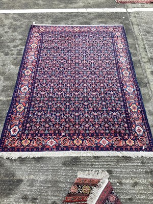 Lot 1435 - Persian design rug on red and blue ground