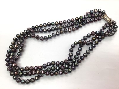 Lot 1025 - Hong Kong black cultured pearl three strand necklace